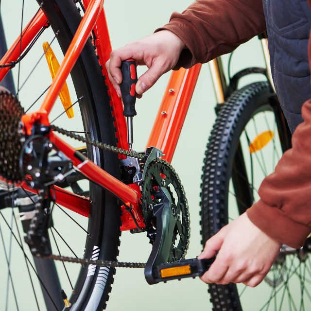 man disassembling his bike with a screwdriver