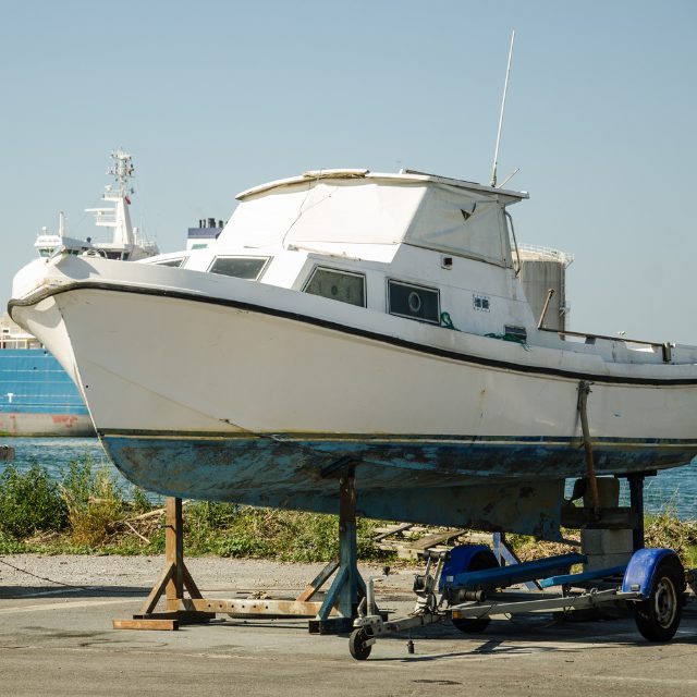 a boat sitting on a trailer near the water